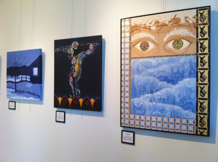 Gallery wall showing three artworks by visionary artist Tonya Henderson. An evening snowy landscape, a figure made of faces, and a tiled artwork with various cultural representaions.