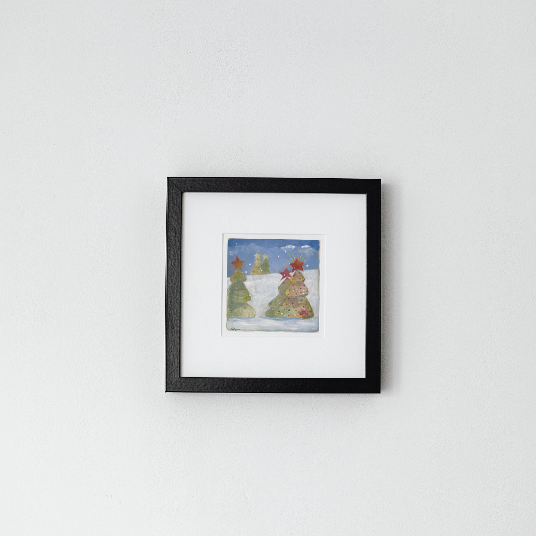 Framed original painting of a snowy landscape with trees on a white wall by artist Tonya Henderson.