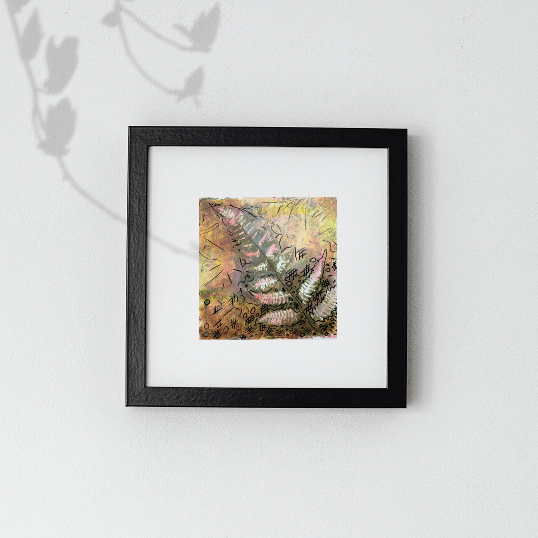 Framed artwork with a colorful abstract design on a white wall