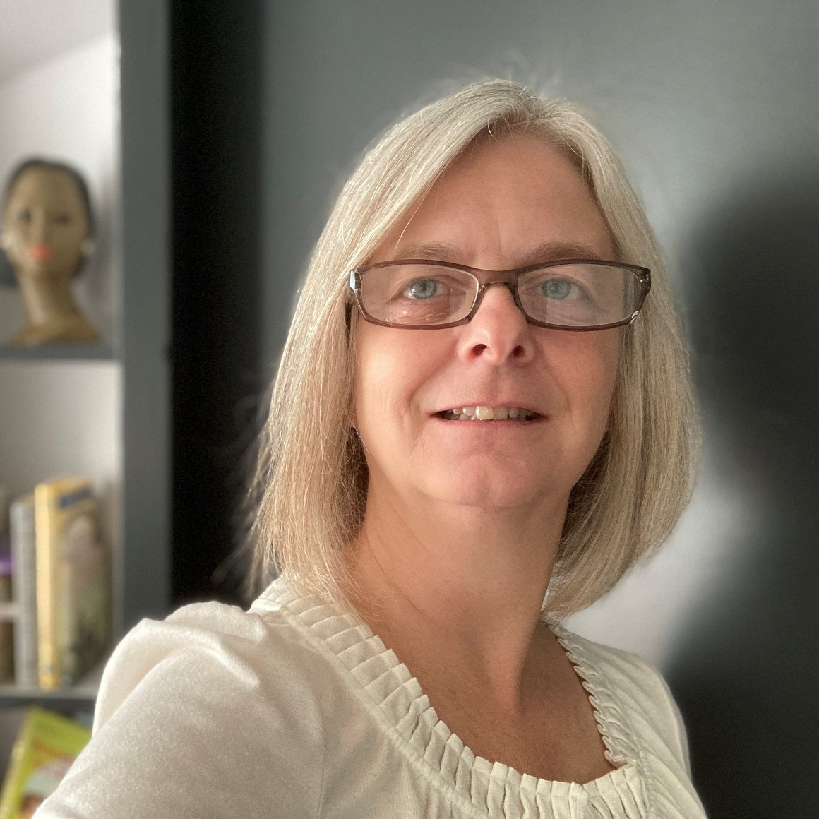 A portrait of visionary artist Tonya Henderson wearing glasses and a white top.
