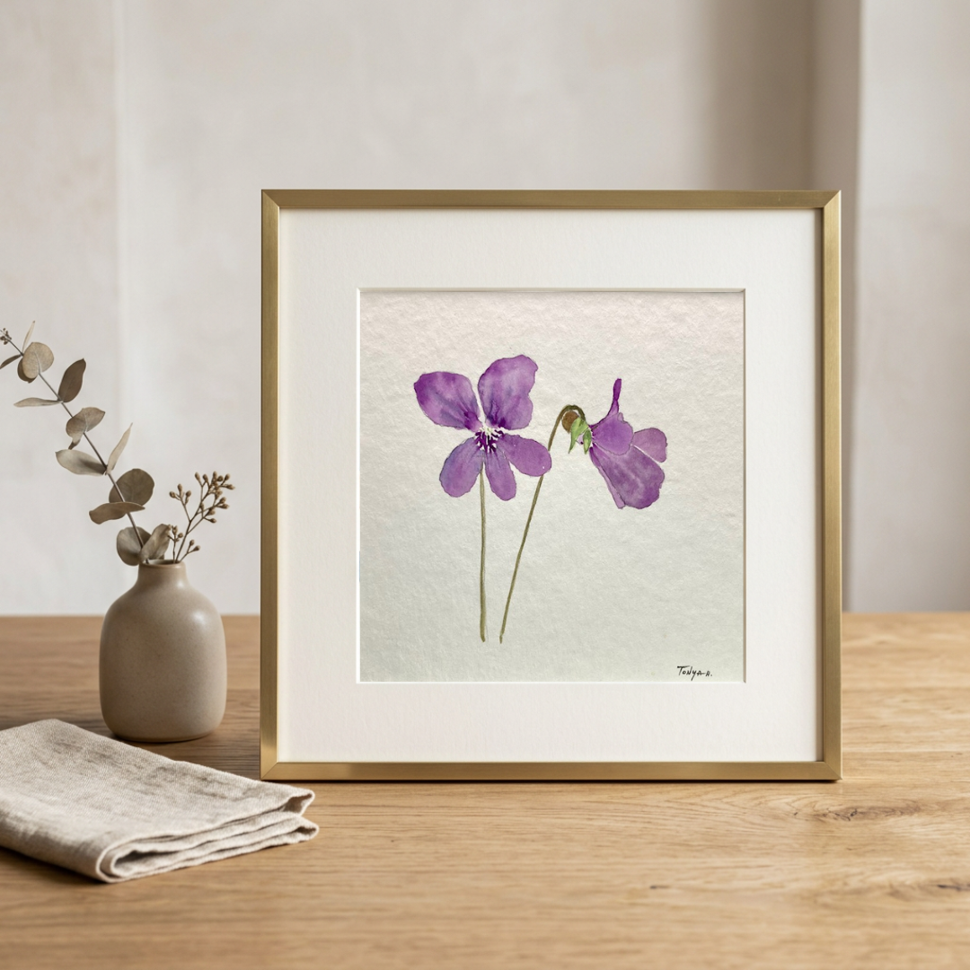 Original watercolor painting of purple violet flowers by artist Tonya Henderson. sitting on a wooden surface with a vase and fabric.
